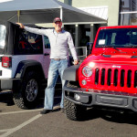 A man standing between two Jeeps