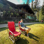 A man reclining on an outdoor chair at the Emerald Lake Lodge