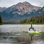 A woman doing yoga positions on top of a paddle board in Pyramid Lake  