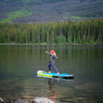 A woman doing yoga while on a paddle board at Pyramid Lake