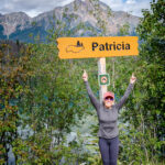 A woman posing in front of a sign to Patricia