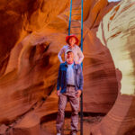 A man and a woman going down a ladder to the Antelope Canyon