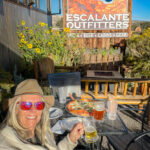 A woman enjoying a meal near the Escalante Outfitters