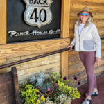 A woman standing in front of the Back 40 Ranch House Grill sign  
