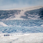 A bus dropping off visitors at the Athabasca Glacier