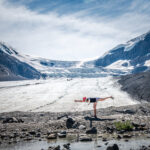 A woman stretching at an ice field in the Rocky Mountains