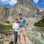 A man and woman at the Emerald Lake shoreline  