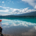 A woman standing on the shoreline of the Emerald Lake  