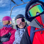 Three people with visors riding a cable car