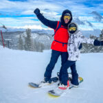 Two people in ski gear hugging while posing for a photo