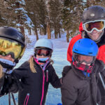 Four people wearing ski gear and visors