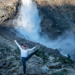 A woman standing on one foot at the Takakkaw Falls