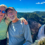 A man and woman taking a photo near the Yellowstone Falls