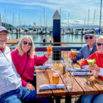 Four people earing near a dock  