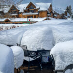 Outdoor tables and chairs covered in snow